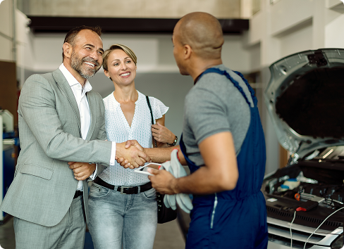 Two people shaking hands in an auto shop